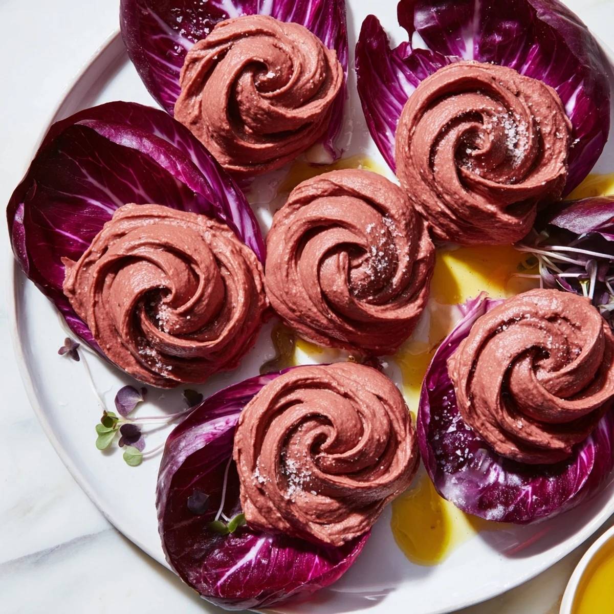 Creamy beet hummus swirls form stunning rose shapes in this The Velvet Rose appetizer, perfect for guests.