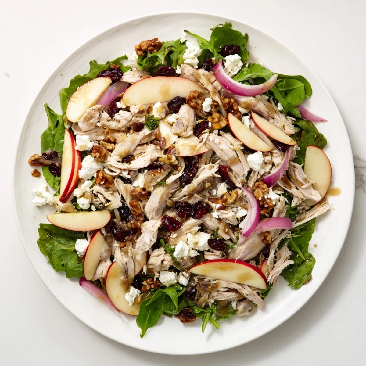 Chicken and Apple Winter Salad with shredded chicken and glistening apple slices, ready to be tossed.