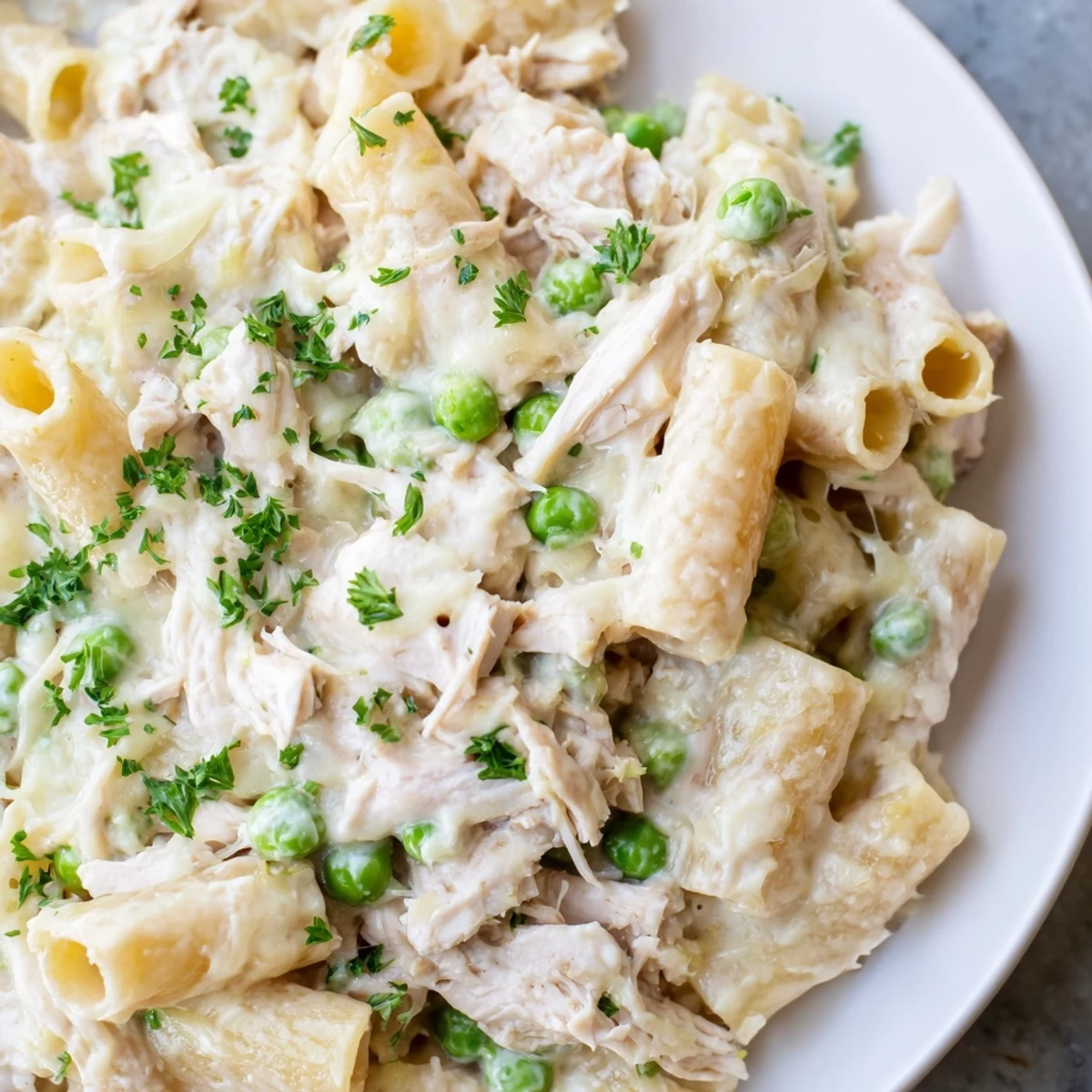Imagine a close-up of the Slow Cooker Chicken Alfredo Pasta Bake, featuring tender chicken and perfectly cooked pasta.
