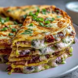 A close-up of a Blooming Quesadilla Ring with golden, crispy edges and fresh cilantro garnish beside a wedge of lime.