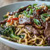 Sizzling aromatics of garlic and ginger infuse this Korean Beef Noodles dish with colorful broccoli, bell peppers, and sesame garnish.