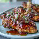 Honey mustard chicken with green beans in a golden skillet, drizzled with tangy sauce and fresh lemon zest.