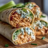 Spicy Buffalo chicken cream cheese spread rolled in tortillas, chilled, and cut into perfect party pinwheels.  