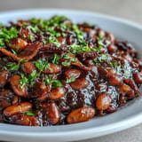 Hearty, slow-cooked Juneteenth BBQ Baked Beans with bacon, bubbling hot from the oven.