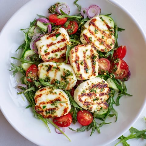 Golden, grilled halloumi and pesto plate with vibrant vegetables, a perfect summer vegetarian meal.