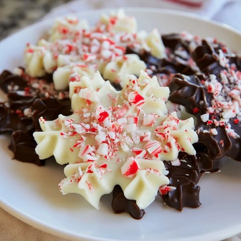 Peppermint Bark Snowflakes: A festive close-up shows layers of dark chocolate, white chocolate, and crushed peppermint.