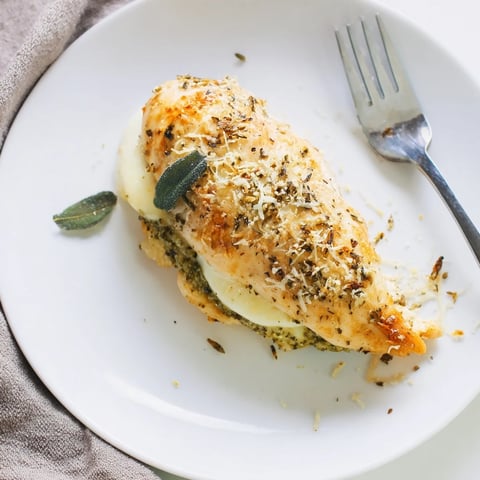 Golden-baked mozzarella and pesto stuffed chicken breasts, sliced to reveal molten cheese and fragrant basil filling for a flavorful Italian main dish.