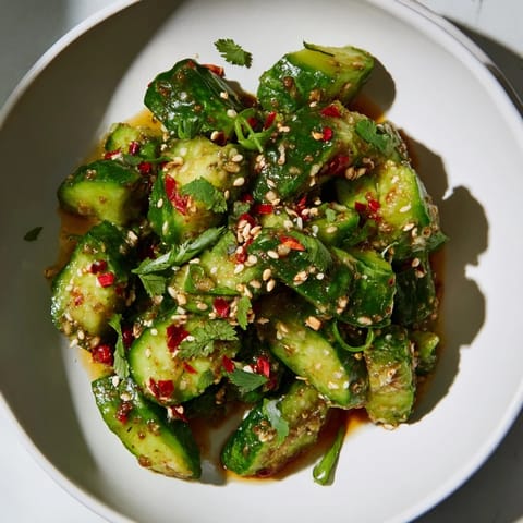 A close-up view of the Chinese Spicy Smashed Cucumber Salad, garnished with sesame seeds and fresh cilantro.