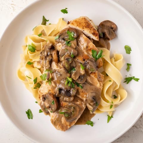 Golden pan-seared chicken breasts nestled in a creamy, rich Marsala wine and mushroom sauce, served over al dente fettuccine for a comforting Italian-inspired dinner.