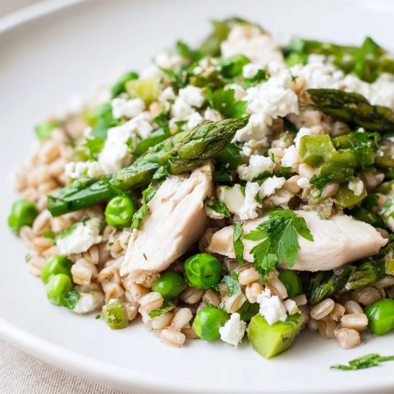 Serving suggestion for Warm Spring Farro Chicken Salad, plated warm with extra lemon zest and fresh mint garnish.
