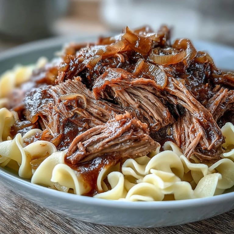 Buttery egg noodles topped with rich French Onion Pot Roast Pasta, garnished with melted Gruyère and fresh parsley.