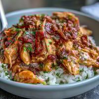 Crockpot Mississippi Chicken Rice Bowls with tender shredded chicken and zesty pepperoncini served over fluffy rice.