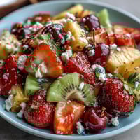 Rainbow Fruit Table with Coconut Whipped Cream: colorful fresh fruit arranged in a vibrant rainbow pattern with a bowl of creamy coconut whipped cream on the side.